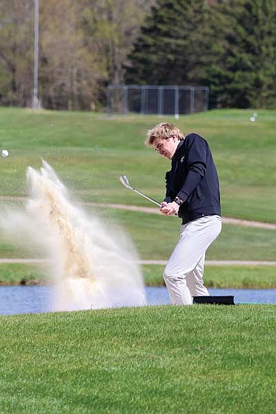 Davis Kock chips the ball out of the bunker on the first hole during the fifth Great Northern Conference meet Monday, May 11 at Black River Golf Course in Medford. Kock tied for second with a 77. (Photo by Matt Frey/Star News)