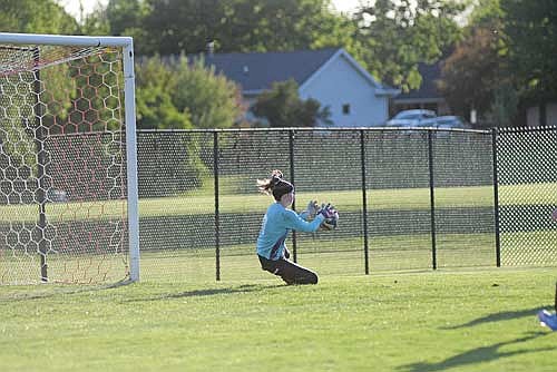 Ava Evenhouse slides to stop the ball in the first half of a non-conference game against De Pere Thursday, May 28 at Cloud Family Field in De Pere. Evenhouse secured a season-high 18 saves. (Photo by Brett LaBore/Lakeland Times)
