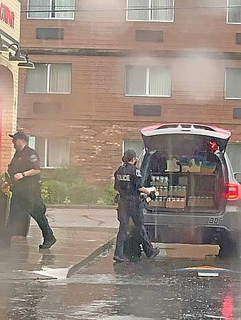 Minocqua police officers assist DOR agents by carting case after case of alcohol from the Minocqua Brewing Company Taproom on Thursday, June 11, in Minocqua. (Contributed photograph)