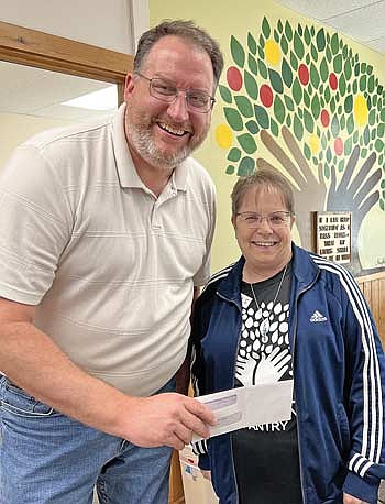 Pastor Mark Gilbert of United Methodist Church of the Pines presents a $4,500 donation to Lakeland Pantry executive director Lorna Springate. The gift, along with a $1,000 donation to the Vilas County Food Pantry, was made possible through the congregation's food security fundraising efforts. (Contributed photograph)