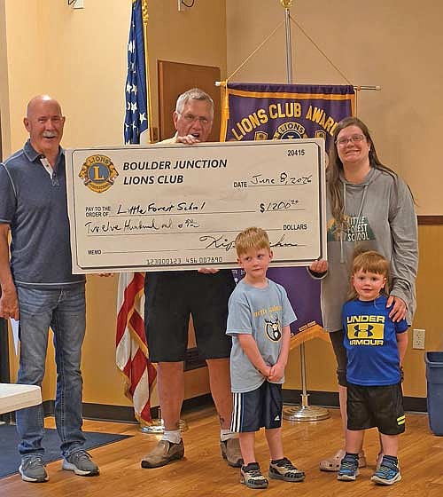 The Boulder Junction Lions Club recently donated $1,200 to Little Forest School in Manitowish Waters. Those present for a check presentation, from left, are: Mike McKeon, Little Forest School board chair; Kip Decker, Boulder Junction Lions Club president; Erica Dischinger, assistant director and preschool co-teacher; and Erica’s sons Barrett and Hawken. (Contributed photograph)