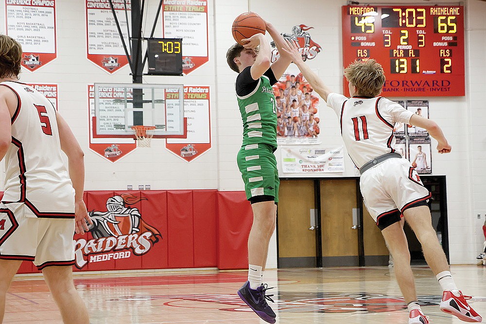 In this Jan. 22, 2026 file photo, Rhinelander’s Devon Feck attempts a 3-pointer with a combination game/shot clock in the background at Raider Hall in Medford. As of this winter Medford was one of only two gyms in the Great Northern Conference with shot clock capabilities. The WIAA approved the use of a shot clock for non-conference games, by mutual agreement of teams, beginning in the 2026-27 season. The full use of the shot clock, starting in 2028-29, will be put to a vote of WIAA member schools at next April’s WIAA annual meeting in Stevens Point. (Jeremy Mayo/River News)