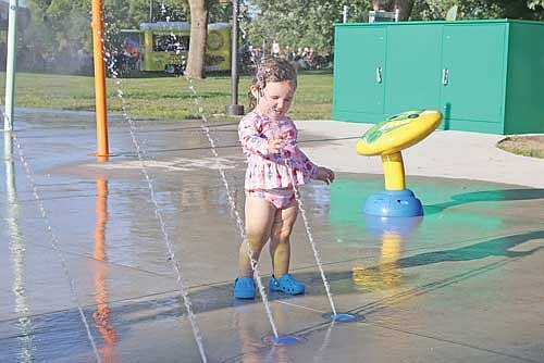 Lily Paukey, 1 1/2, finds relief from the heat at the Hodag Park splash pad Tuesday, July 14. Northwoods residents felt a 1-2 punch from Mother Nature this week between abnormally warm temperatures and wildfire smoke. (Photo by Bob Mainhardt for the River News)