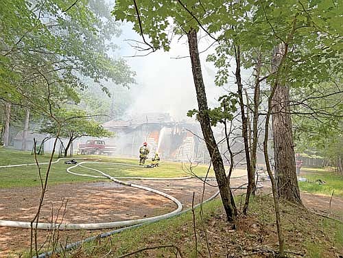 Firefighters keep a fire hose trained on a fire at a duplex on White Pine Lane in Arbor Vitae on Saturday, June 11. (Photo by Heather Holmes/Lakeland Times)