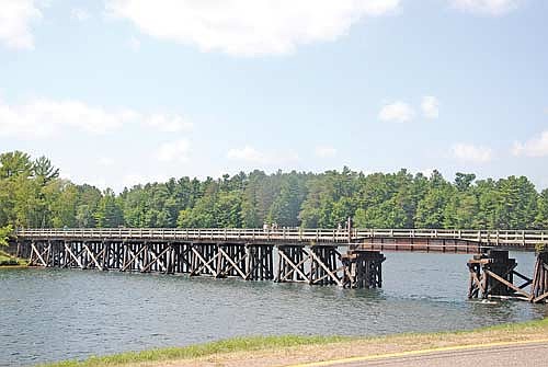People stroll and stop on the Bearskin Trail’s Minocqua trestle on Lake Minocqua on Monday, July 20. (Photo by Brian Jopek/Lakeland Times)