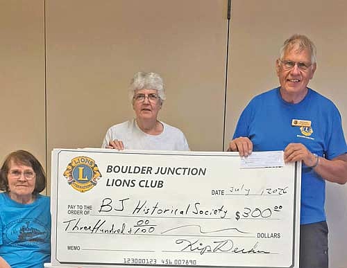 Josie Blaisdell-Allen, left, Jane Blaisdell, middle, and Kip Decker, right, hold the Boulder Junction Lions Club’s $300 donation to the Boulder Junction Area Historical Society. (Contributed photograph)