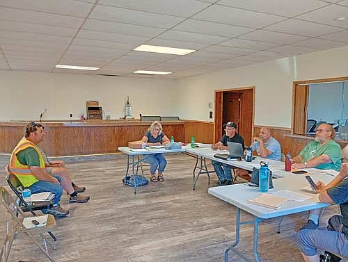 Jeff Seamandel (left) of engineer MSA Professional Services delivers an update on the town’s $4 million ARIP road project to (l-r round the table) clerk Stacy Schickert, supervisors RIch Hirman, chairperson Casey Crump and Jerome Pokorny, and treasurer Sara Zastrow, at the Stella town board’s July 14 meeting. (Photo by Ardith Carlton/River News)