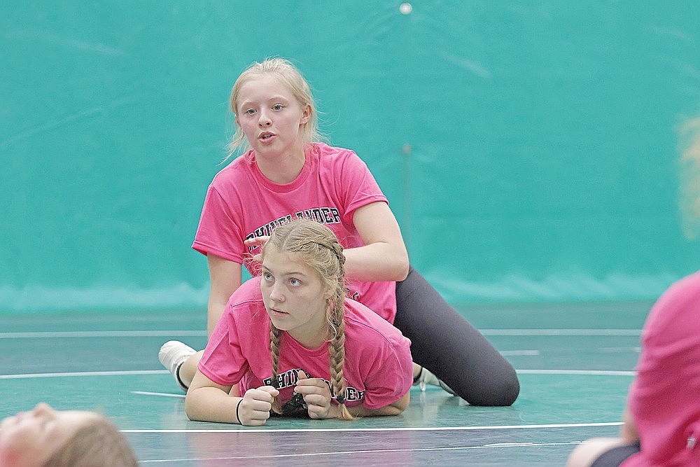 Cassidy Lindner, top, demonstrates a move with teammate Skylar Leitl, bottom, during the Hodag girls’ wrestling camp at the Jim Miazga Community Gymnasium Monday, Aug. 3. Twenty-two wrestlers, ranging from preschool to entering eighth grade, took part in the roughly two-hour camp. (Jeremy Mayo/River News)