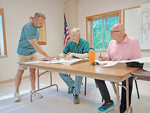 Examining a map of a proposed 16-lot residential subdivision off Wausau Road are (l-r) surveyor Gregory Maines and the Crescent Town Plan commission’s Michael Pazdernik and David Holperin Aug. 5 at Crescent town hall. (Photo by Ardith Carlton/River News)