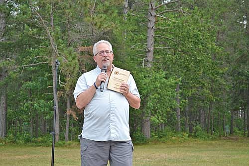 Dennis Duke stands with the 2026 Wisconsin Governor’s Outdoor Industry Rising Star Award. (Contributed photograph)