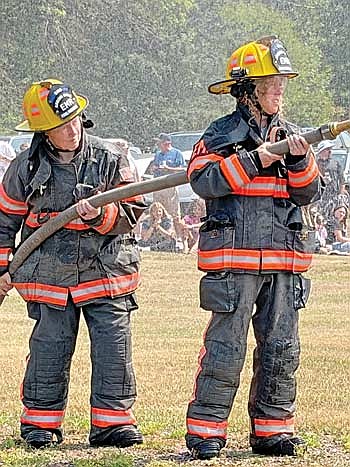 Dawn Greenman, left, and Lexi Morgan with Arbor Vitae Fire and Rescue, get ready for a waterfight during the Hazelhurst volunteer fire department’s annual picnic on Saturday, Aug. 8. (Photo by Brian Jopek/Lakeland Times)