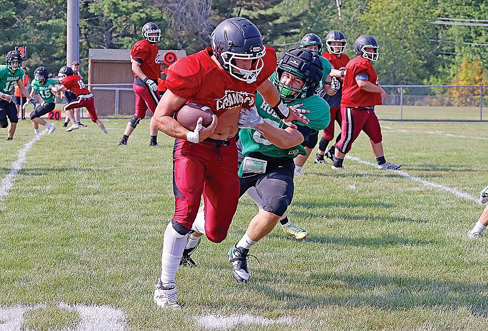 Rhinelander’s Tommy Eades attempts to tackle a Crandon ball carrier during a football scrimmage against Shawano in Wittenberg Friday, Aug. 14. (Bob Mainhardt for the River News)