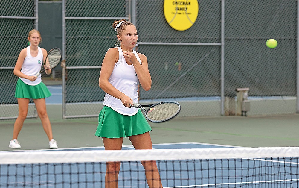 Rhinelander’s Sam Aschenbrenner plays a point at the net while doubles teammate Addy Currie, background, looks on during a non-conference girls’ tennis match against Ironwood, Mich. at the RHS tennis courts Friday, Aug. 21. Aschenbrenner and Currie went 3-0 on the day at No. 1 doubles as the Hodags won all three of their dual meets in a home quadrangular. (Bob Mainhardt for the River News)