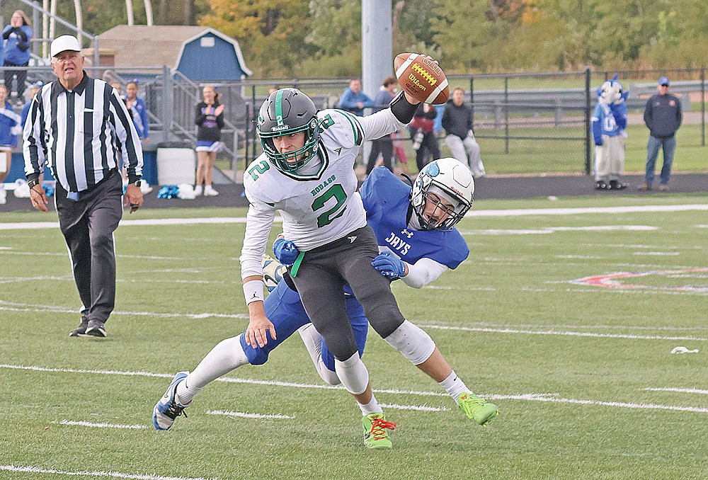 Rhinelander’s Abe Gretzinger attempts to escape pressure from Merrill’s Jamis Hanson during the fourth quarter of a GNC football game at Merrill Saturday, Oct. 3. Gretzinger was sacked eight times and held to a season-low 70 yards passing in a 37-0 loss to the Bluejays.