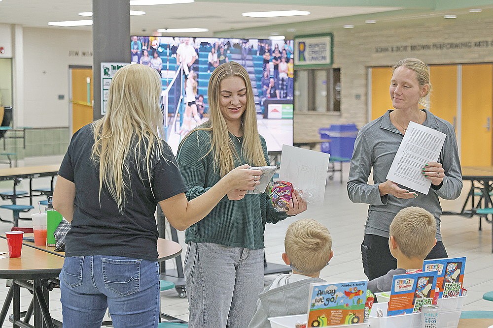 Ava Rathbun receives the Rhinelander High School volleyball team’s offensive leader award from assistant coach Anne Buchmann while head coach Jayme Wyss, right, looks on during the team’s banquet in the RHS commons Sunday, Oct. 25.